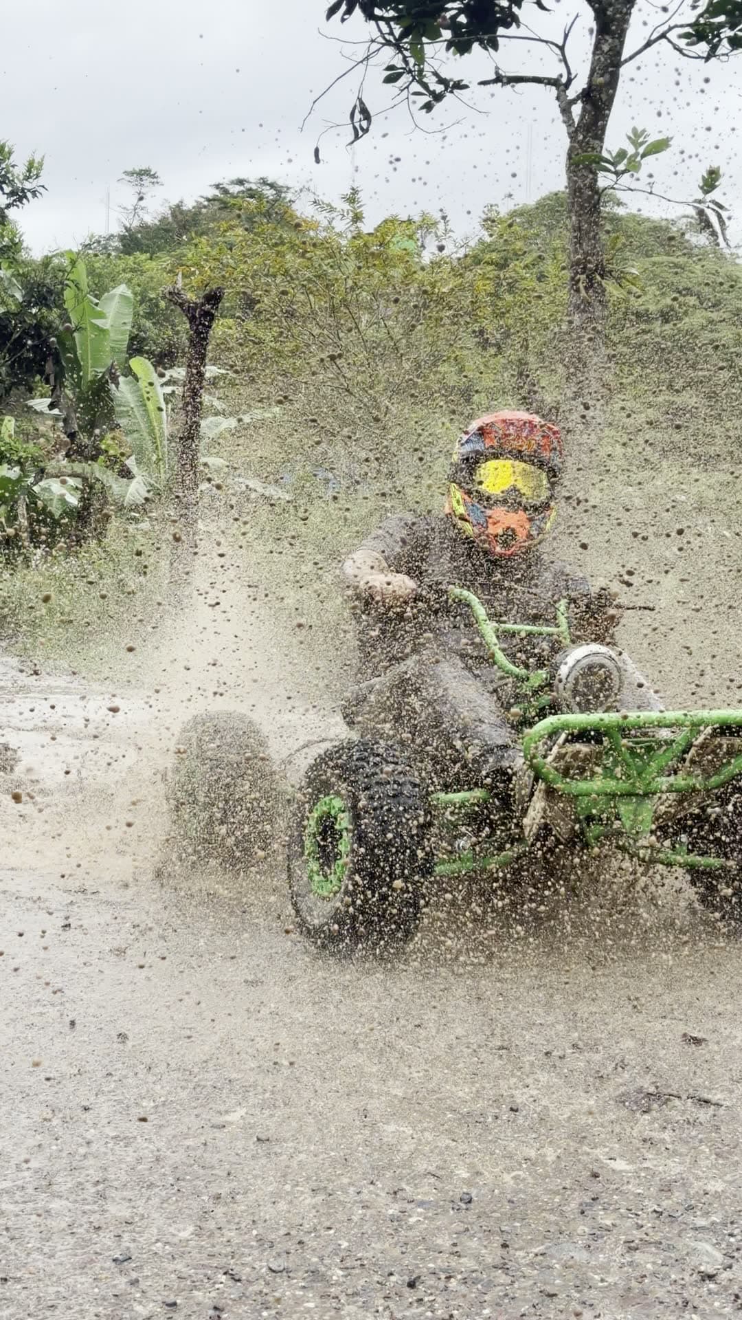 Kart salpicando barro al cruzar un charco del recorrido